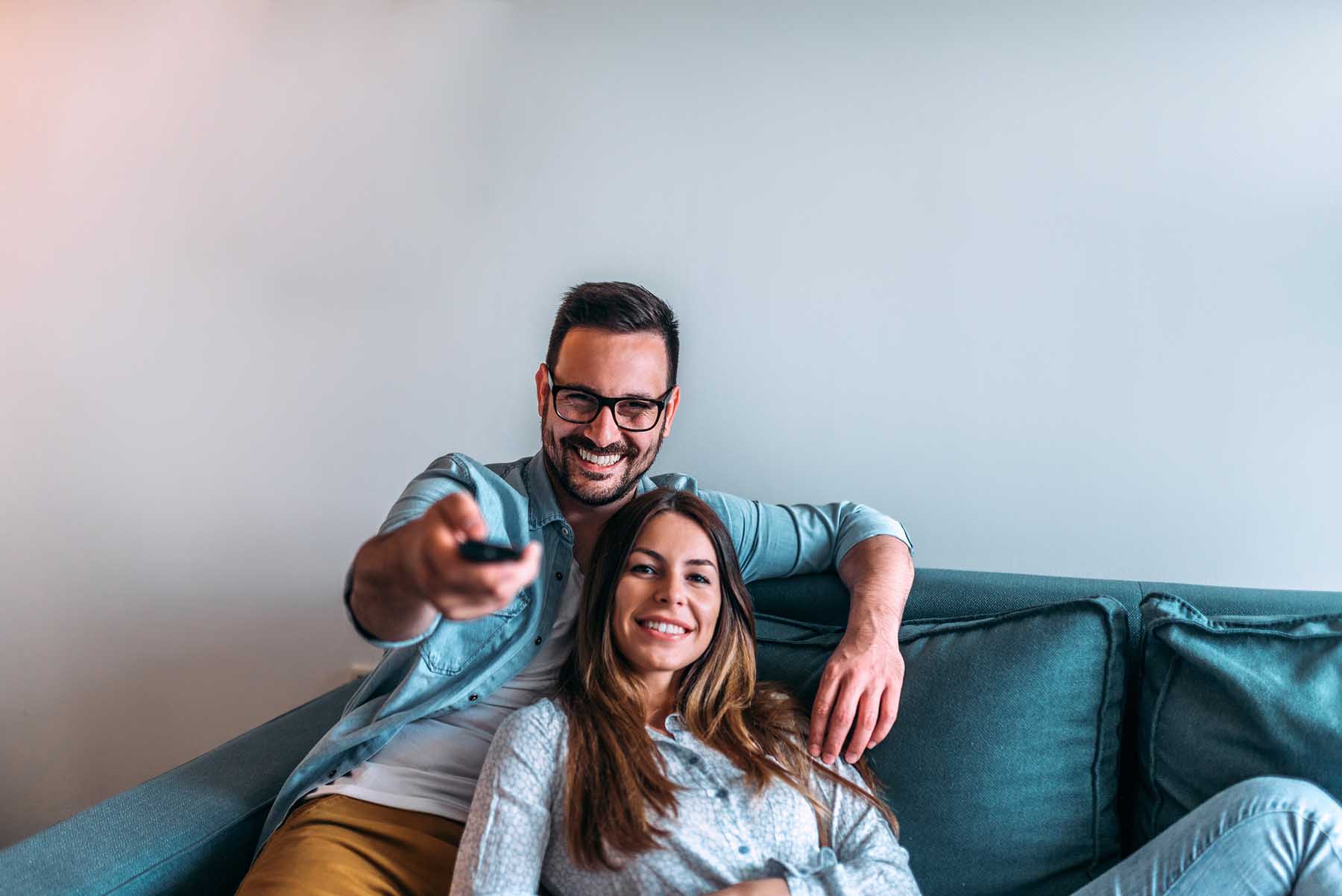 Pärchen auf Couch mit Fernbedienung